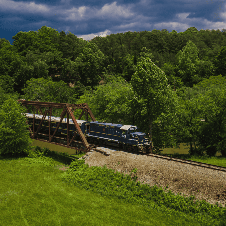 the blue ridge scenic railway train travels over a historic bridge in the scenic north Georgia region.